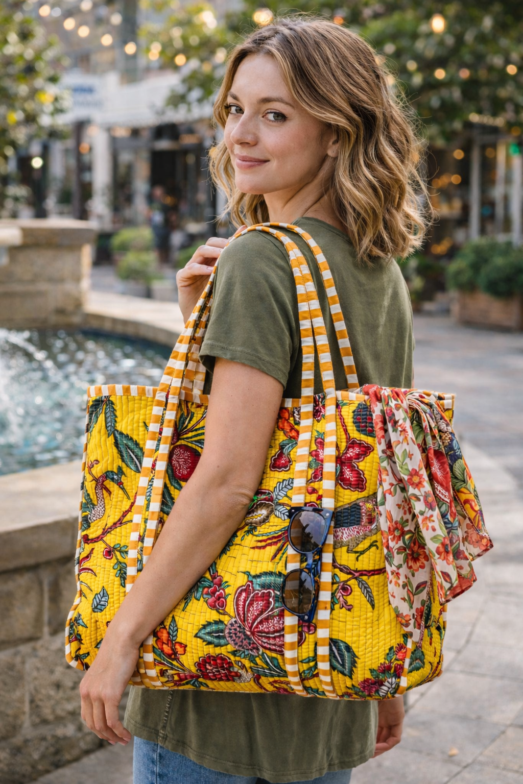 Woman holding a large, colorful floral-patterned bag outdoors.